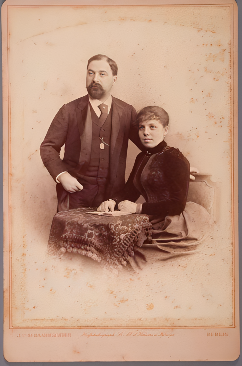 Retrato de um homem e uma mulher junto a uma mesa.