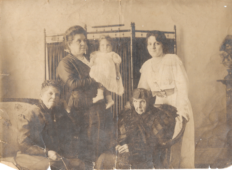 Grupo de mulheres e uma criança em uma fotografia de família.